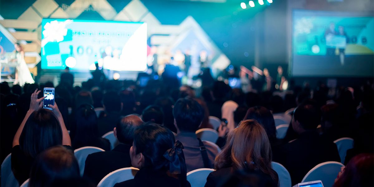 plateia acompanhando uma palestra em um evento de marketing
