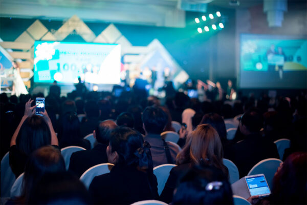 eventos-de-marketing-destaque plateia acompanhando uma palestra em um evento de marketing