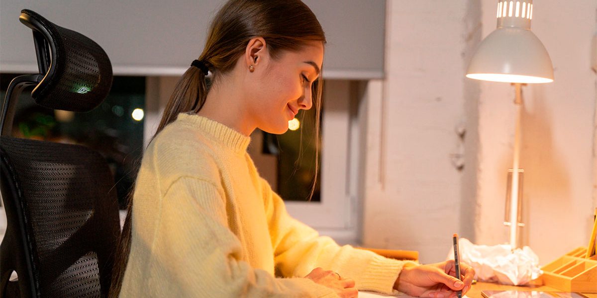 tendencias-de-marketing-2023—-destaque Mulher contente ao escritório estudando sobre as tendências de marketing pra 2023